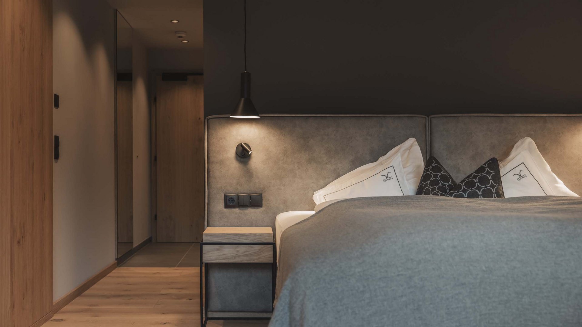 Modern bedroom with gray bed and wooden floor